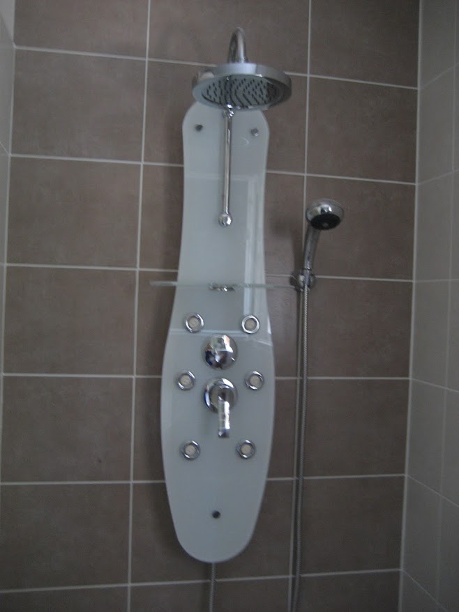 Colonne de douche installée sur un mur carrelé